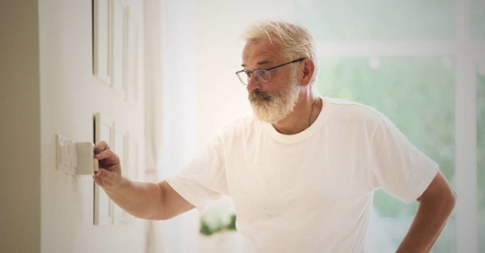 Man adjusting thermostat