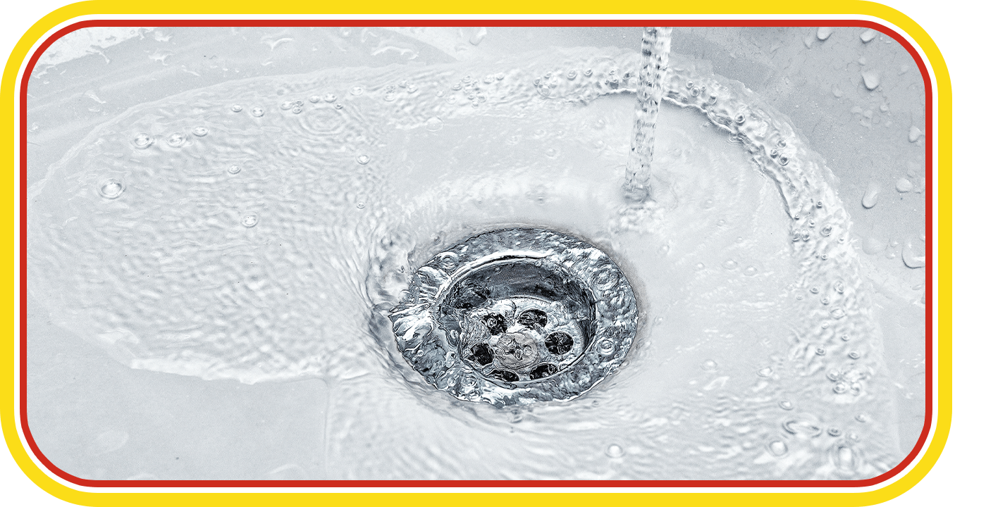 A metal sink drain with water swirling around it.